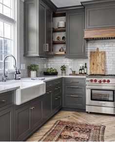 a kitchen with gray cabinets and an area rug