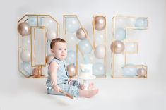 a baby sitting on the floor with a cake