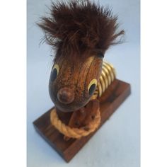 a wooden toy with hair on top of it