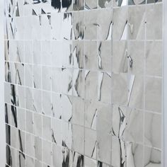 a white tiled wall with black and white tiles