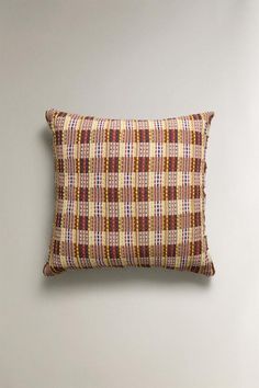 a brown and white pillow sitting on top of a wall