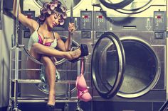 a woman sitting on top of a dryer in front of a washer machine