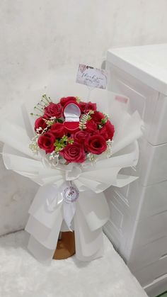 a bouquet of red roses wrapped in white paper