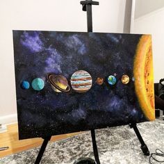 the solar system is painted on an easel