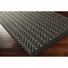 a black and white rug with an arrow pattern on the bottom, sitting on a wooden floor