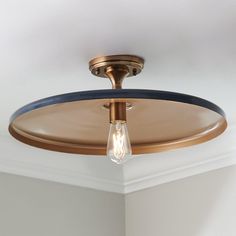 a light that is on the ceiling in a room with white walls and flooring