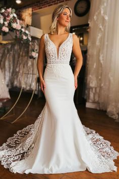 a woman in a white wedding dress posing for the camera