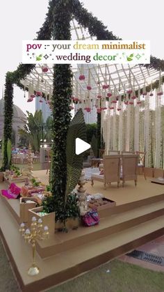 a stage set up for a wedding ceremony with flowers and greenery on the side