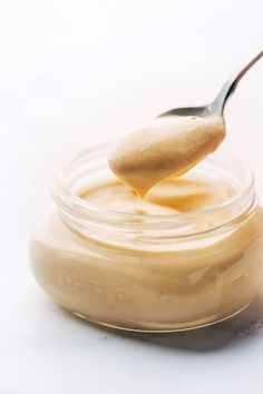 a spoon full of peanut butter on top of a jar