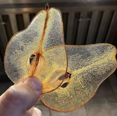 a person holding up a piece of fruit with the skin peeling off it's face