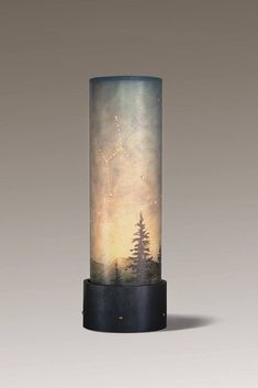 a tall glass vase with trees on it