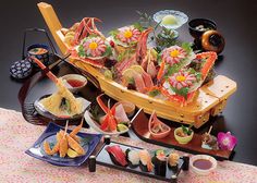 there are many different types of sushi on the table with chopsticks and sauces