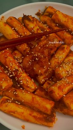 a white plate topped with tofu sticks covered in sesame seeds