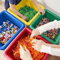 three children are playing with different colored beads