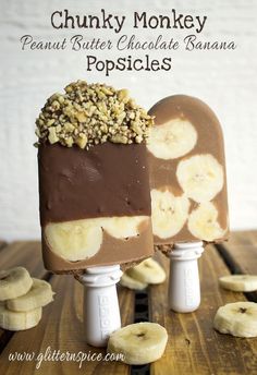 two popsicles with chocolate and banana slices on them, sitting on top of each other