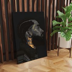 a black and gold portrait of a man on a wooden wall next to a plant