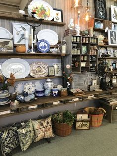 a room filled with lots of different types of plates and vases on top of shelves