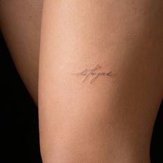 a woman's thigh with the word love written on it in cursive writing