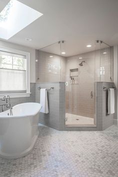 a white bath tub sitting inside of a bathroom next to a window