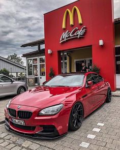 a red car parked in front of a mcdonald's