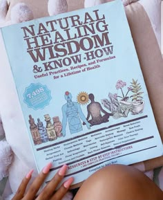 a woman laying on top of a bed next to a book titled natural healing wisdom and know - how