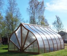 a large metal structure sitting on top of a lush green field