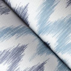 blue and white fabric with small brush strokes on the back of it, as well as an upholstered background