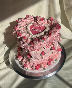 a heart shaped cake with pink frosting and roses