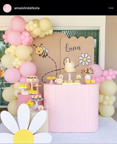 a pink and white dessert table with balloons