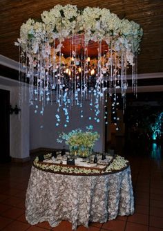 a table topped with flowers and candles under a chandelier