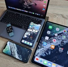 three different types of cell phones and laptops sitting on a table next to each other