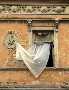 an old building with a curtain hanging from it's window