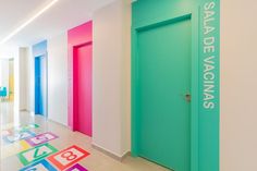 this is a hallway with colorful doors and floor tiles on the floor in front of it