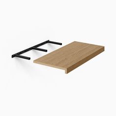 a wooden shelf with two black brackets on it