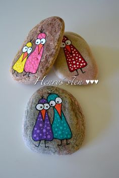 three birds painted on rocks sitting next to each other