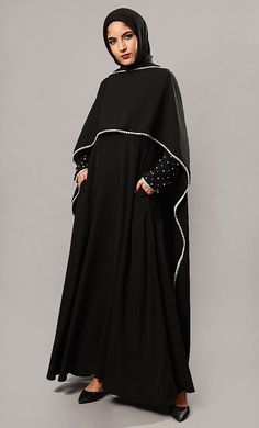 Featuring a beautiful traditional cape style abaya dress in nida fabric adorned with white pearls applique work on the sleeves. It has a whide layer of stole attached on both sides of the shouders with contrast color piping at the edges. Its a modest wear and modern vintage style ensemble perfect to wear in the evening.FIT : Relaxed fit.COMPOSITION : Nida.CARE : Dry clean only. Abaya Fashion Modern, Modern Abaya, Abaya Outfit, Embroidered Cape, Modern Vintage Style, Muslim Dresses, Applique Work, Muslim Fashion Hijab Outfits, Cape Style