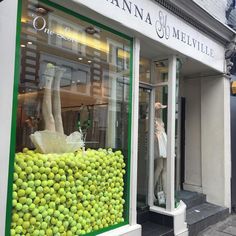 mannequins are displayed in the window of a clothing store with limes on display