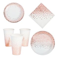 a set of pink and white dinnerware with gold dots on the plates, napkins and cups