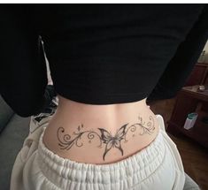 a woman with a butterfly tattoo on her lower back and the bottom part of her stomach