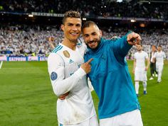 two soccer players pose for a photo on the field with their arms around each other