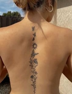 the back of a woman's neck with flowers and butterflies on her left side