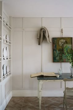 a room with a table, bookshelf and chair