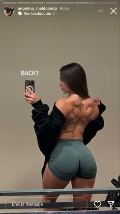 a woman taking a selfie with her cell phone and showing off her back muscles