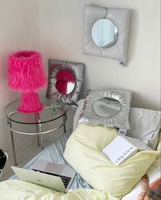 a bed room with a laptop computer on top of it next to pillows and other items