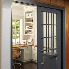 an open door leading into a kitchen with wooden floors