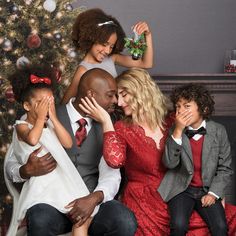 a family sitting in front of a christmas tree