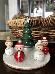 a group of small figurines sitting on top of a table next to a christmas tree