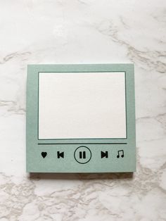 an electronic device sitting on top of a white counter next to a tile wall with music notes written on it