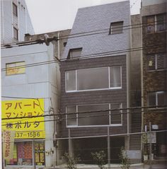 an old photo of a building behind a chain link fence