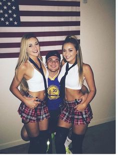 two girls and a man posing in front of an american flag